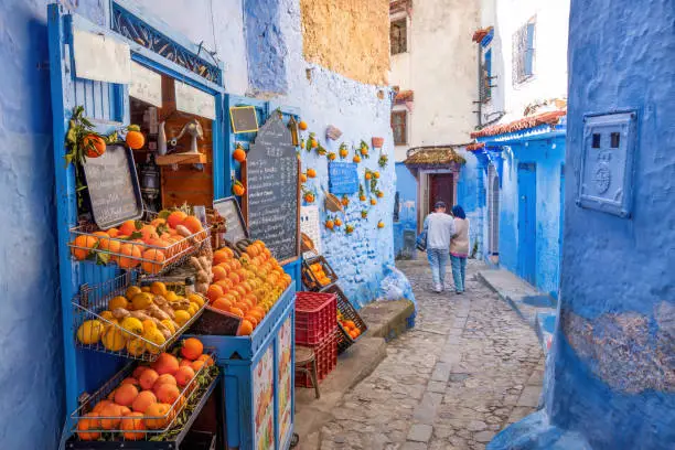Fruit shop on a blue-painted street in Chefchaouen, Morocco.